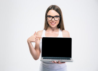 Smiling girl pointing finger on a blank laptop screen