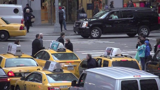 Slow Motion view of pedestrians and cars at NYC intersection