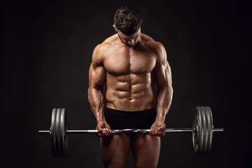 Fototapeta na wymiar Muscular bodybuilder guy doing exercises with big dumbbell