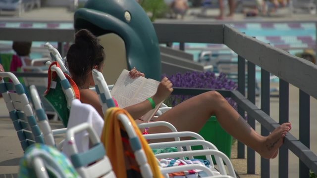 Girl reading at community pool