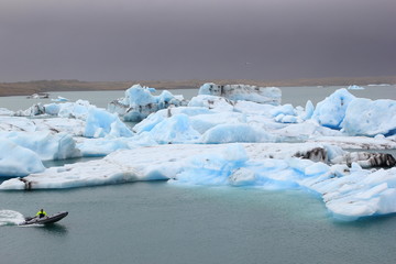 Fototapeta na wymiar Gletschersee Jökulsarlon mit Eisbergen und Motorboot auf Island