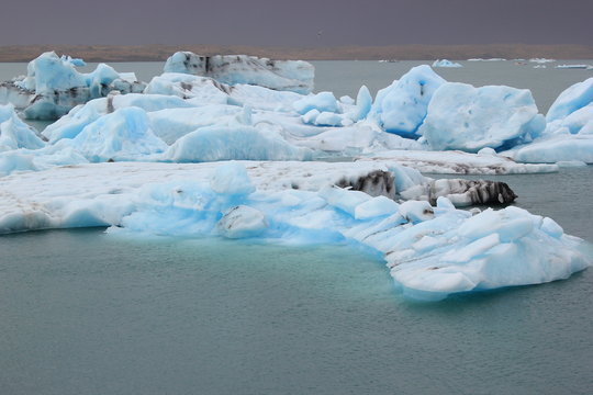 Gletschersee Jökulsarlon auf Island mit blau schimmernden Eisbergen