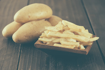 french fries on wood background - soft focus with vintage film f