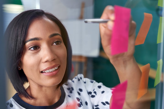 businesswoman writing on post it note