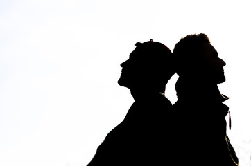 Silhouette - couple of friends relaxing leaning on each other - casual lifestyle  - people, lifestyle concept
