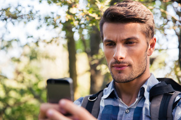 Man using smartphone in the forest