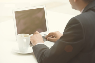 business man using laptop with coffee in the morning