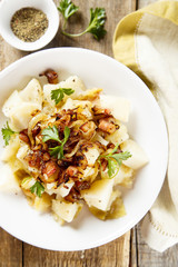 Potato salad with apples, fried onion and ham