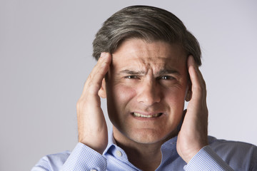 Studio Portrait Of Man Suffering With Headache