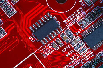 Closeup of red electronic motherboard circuit with processor