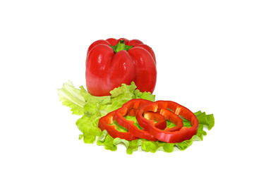 Petite red pepper and slices on a green leaf lettuce. Water drops on peppers. Juicy slices of pepper and fresh green salad leaf. Close-up.