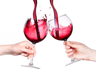 Glasses of red wine with splashes in hand isolated