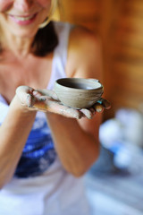 Fototapeta na wymiar Closeup woman hands after workshop in artisan studio holding a clay pot