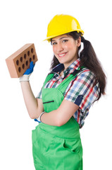 Female workman in green overalls holding brick isolated on white