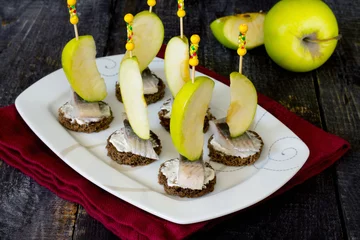 Foto op Plexiglas Appetizer canape with herring, apples and black bread © elena_hramowa