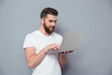 Smiling casual man using laptop computer