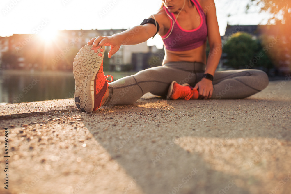 Wall mural female athlete stretching legs