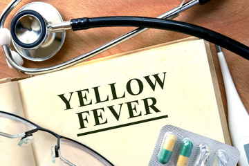 Yellow Fever concept. Book with stethoscope and pills.