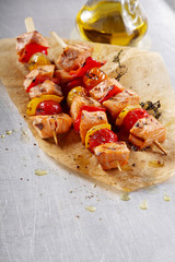 Three Fish Kebabs on Paper on Top of a Table