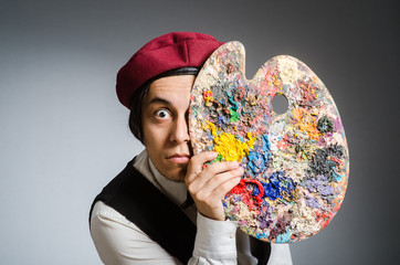 Funny artist in dark studio