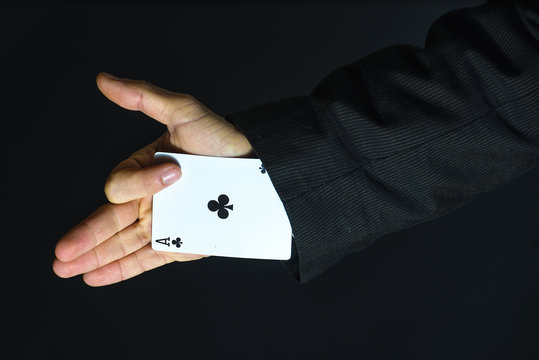 Man with ace up his sleeve on black background