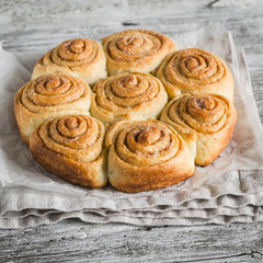 cinnamon rolls on bright wooden surface