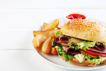 Pastrami and salad roll with potato wedges