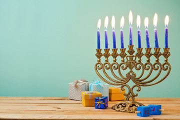 Jewish holiday Hanukkah background with vintage menorah and gift boxes on wooden table