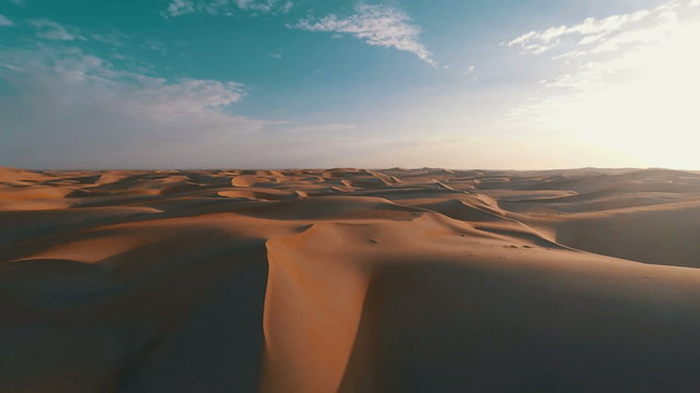 Aerial shot panning around dunes in the desert