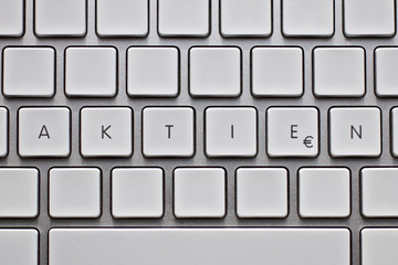 Leere Aluminium-Tastatur mit Text "Aktien" und Textfreiraum für weiteren Text