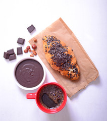 Chocolate croissant on white wooden background