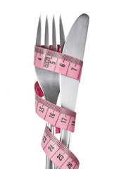 Measuring tape wrapped around a fork and a knife