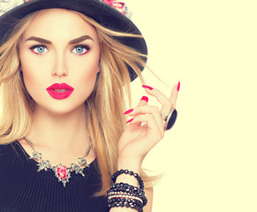 Beautiful sexy blonde woman with red lips and manicure in modern black hat