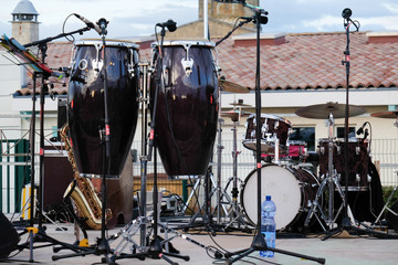 Musical instruments on stage for the outdoor concert : conga, saxophone, drums, microphones