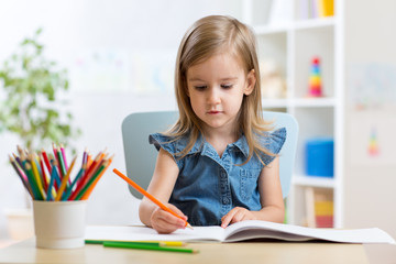 child girl paints in her nursery