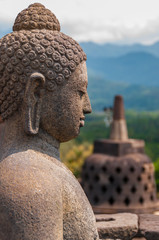 Sitting stone Buddha in front of Stupa at borobudur