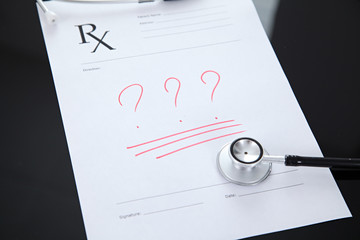 Stethoscope and prescription, black reflective background