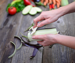 Woman's hand peeling fresh eggplant