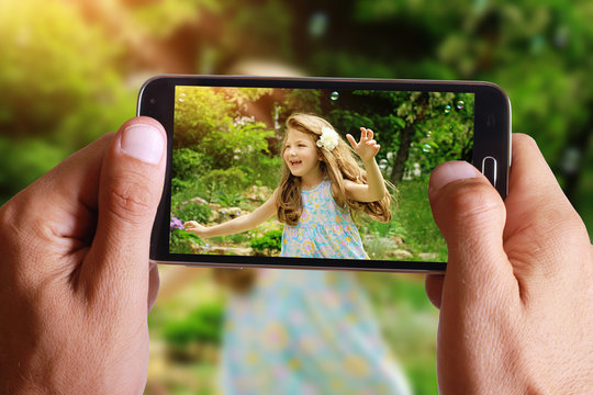 Male hand taking photo of Vintage Portrait of beautiful girl with cell, mobile phone. Kids, childhood, family concept.