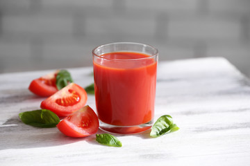 Tomato juice and fresh tomatoes on wooden table close-up