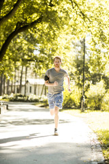 Fototapeta na wymiar Young man running in the autumn park