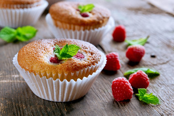Delicious cupcakes with berries and fresh mint on wooden table close up