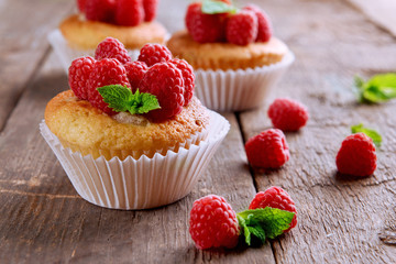 Delicious cupcakes with berries and fresh mint on wooden table close up