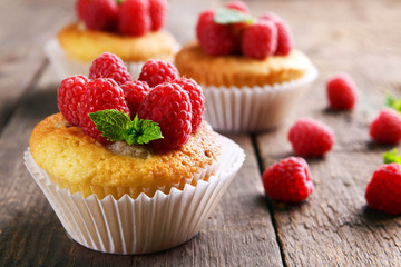 Delicious cupcakes with berries and fresh mint on wooden table close up