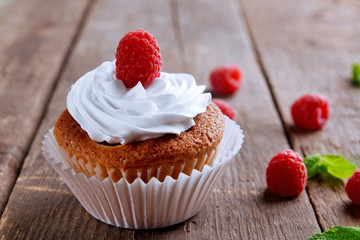 Delicious cupcake with berries and fresh mint on wooden table close up