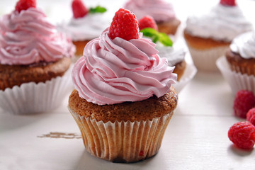 Delicious cupcakes with berries on table close up