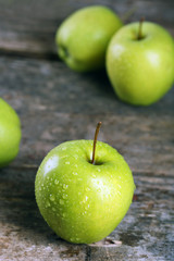 Ripe green apples on wooden table close up