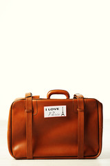 Suitcase with stickers on floor in room