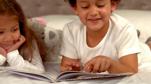 Hispanic children reading a book together