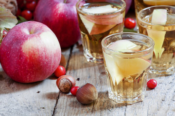 Apple juice with slices of fresh apples in the autumn background